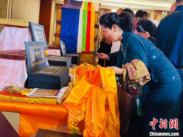 圖為現(xiàn)場藏族民眾向黃金書寫的大藏經(jīng)《甘珠爾》敬獻(xiàn)哈達(dá)。　孫睿 攝