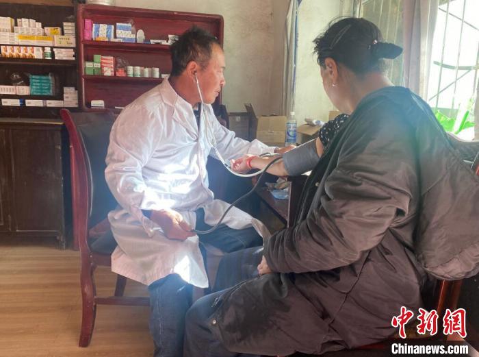 索木滾(左)為村民看病。　壤塘縣委宣傳部供圖