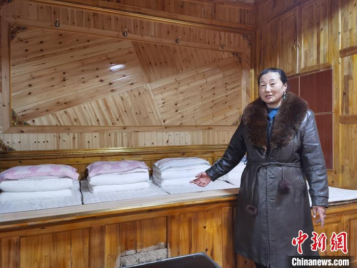圖為德吉村村民鬧尖措介紹自家農(nóng)家樂?！∑钤鲚?攝