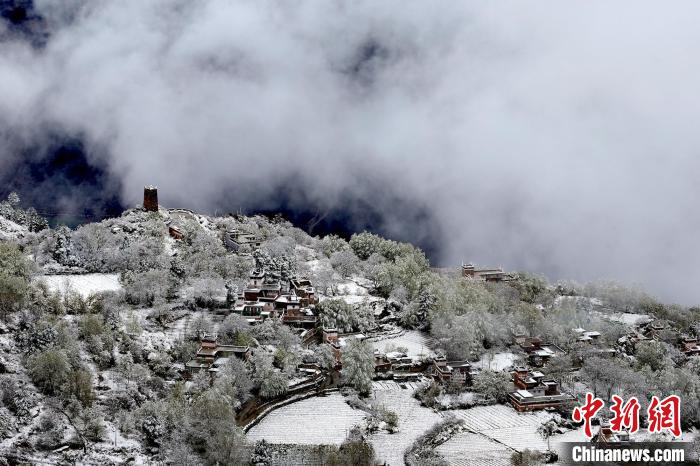 雪后的藏寨和碉樓構(gòu)成美麗的雪景?！〗党鯘衫?攝