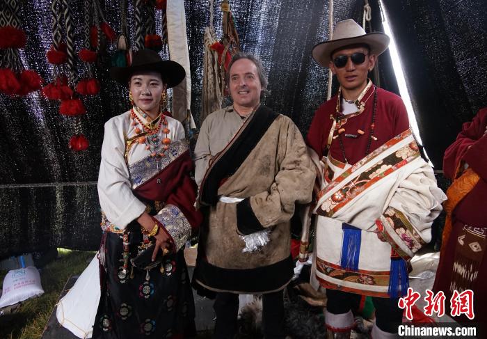 圖為一名外籍?dāng)z影師(中)身穿藏服和藏族民眾合影留念?！●R銘言 攝