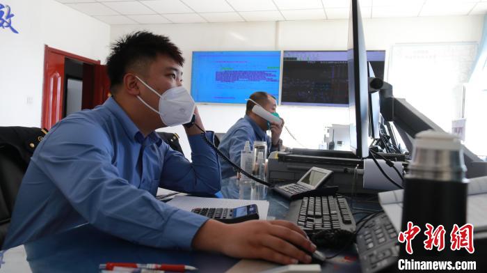 圖為貨運(yùn)調(diào)度人員與外勤工作人員聯(lián)系掌握車輛裝載情況?！±钌?攝