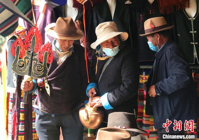 圖為三位藏族老人在集市上聊天交談?！∪轿木?攝