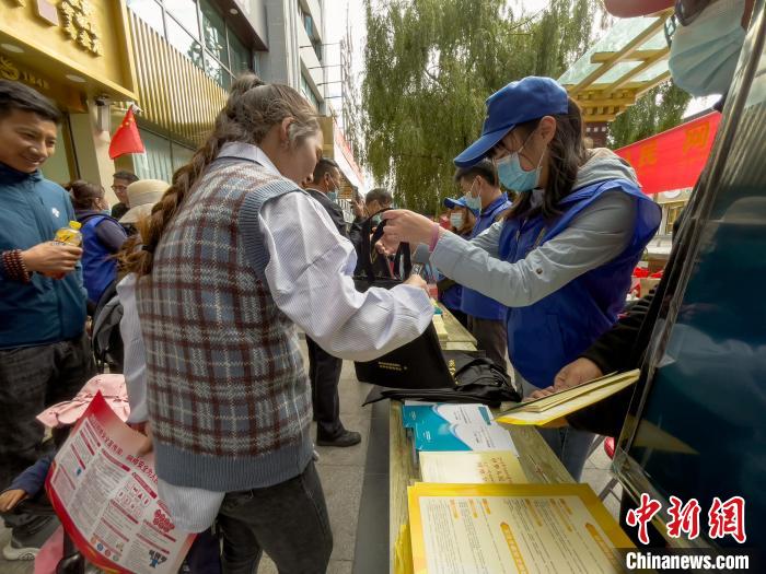 圖為志愿者為市民發(fā)放網(wǎng)絡(luò)安全宣傳手冊(cè)?！≈x牧 攝