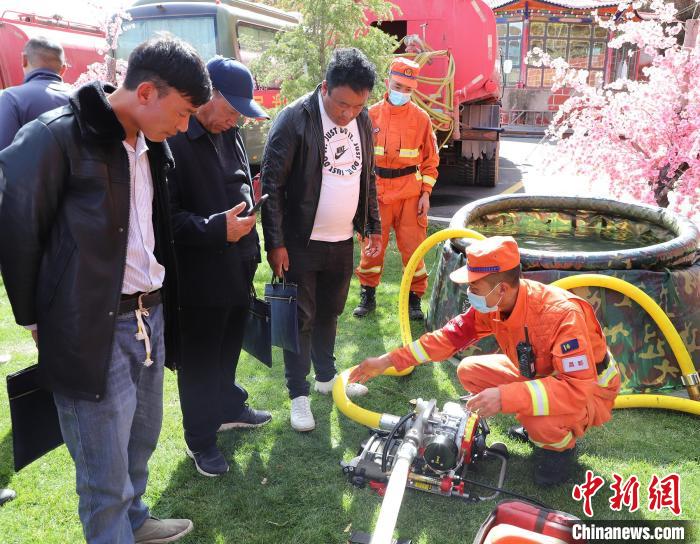 圖為森林消防員為護(hù)林員講解滅火裝備的使用方法?！〔际猩窒乐ш?duì) 供圖