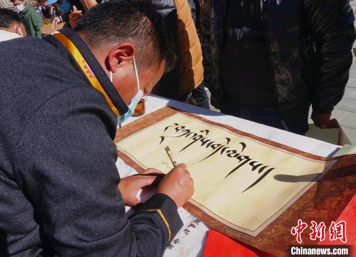 圖為書法家展示藏文書法?！∪轿木?攝