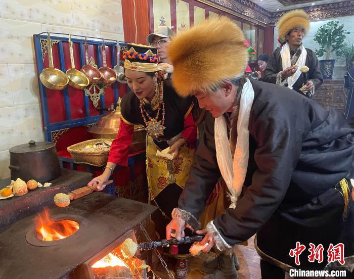 圖為人們?cè)诨鹕峡竟?jié)日美食“結(jié)達(dá)”?！∪轿木?攝