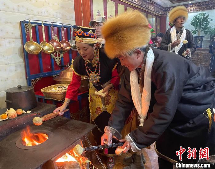 圖為人們在火上烤節(jié)日美食“結(jié)達(dá)”。　冉文娟 攝