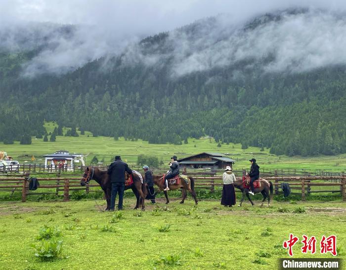 6月10日，游客在魯朗小鎮(zhèn)高山牧場景區(qū)體驗騎馬?！∪轿木?攝