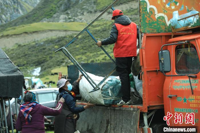 圖為工作人員幫助牧民們卸家具?！÷蹇?攝