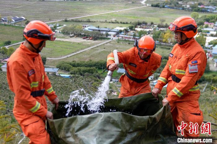 技能大練兵過程中，消防員在陡坡上向蓄水池注水?！±顕鵂c 攝