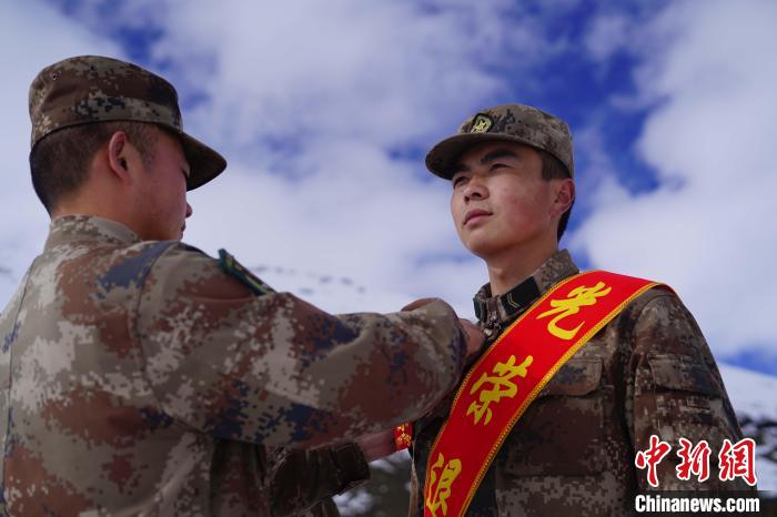 排長王朝偉(圖左)給退伍老兵佩戴大紅花?！∥鞑厣侥宪姺謪^(qū)某團(tuán)供圖