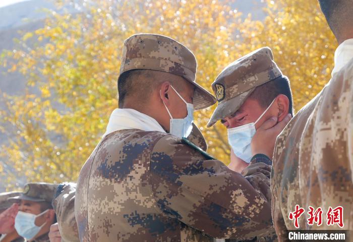 圖為什布奇邊防連退伍老兵與戰(zhàn)友相擁而泣，依依惜別?！⌒觳?攝