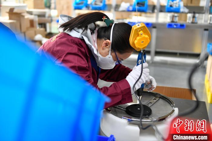 圖為工人正在組裝炊具?！∝暩聛硭?攝