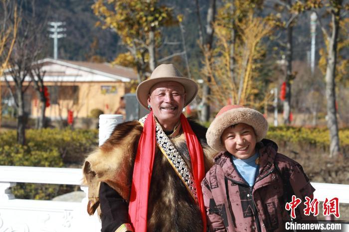 圖為林芝市巴宜區(qū)布久鄉(xiāng)仲果村村民桑杰與孫子一起參加藏歷新年活動(dòng)?！埩?攝