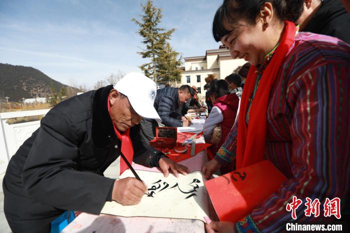 圖為林芝市文聯(lián)書(shū)法家協(xié)會(huì)會(huì)員向民眾贈(zèng)送藏文書(shū)法作品?！埩?攝