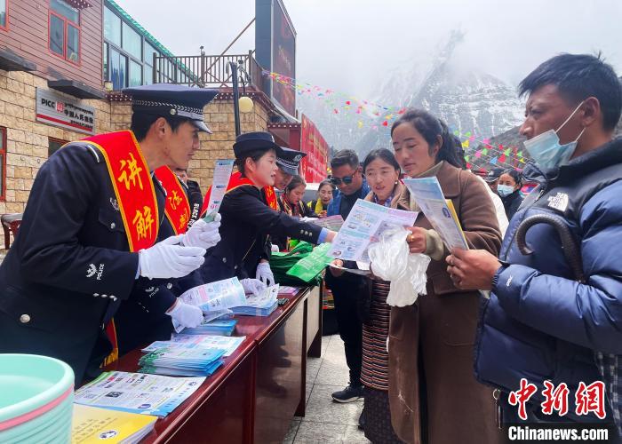 圖為山南玉麥邊境派出所民警為轄區(qū)群眾發(fā)放法律知識宣傳單?！＄婗?　攝