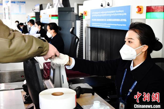 圖為機(jī)場工作人員為旅客辦理行李托運(yùn)。　周航 攝