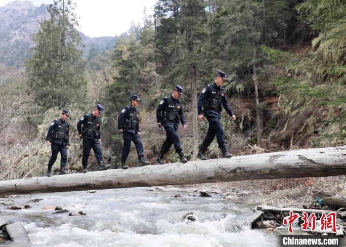 山南邊境管理支隊玉麥邊境派出所民警邊境巡邏途中走過河道上“獨木橋”。　鄭琦山 攝
