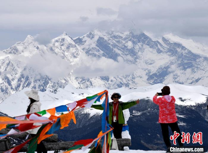 圖為5月14日，西藏林芝色季拉山觀景臺(tái)，游客與南迦巴瓦峰合影?！±盍?攝