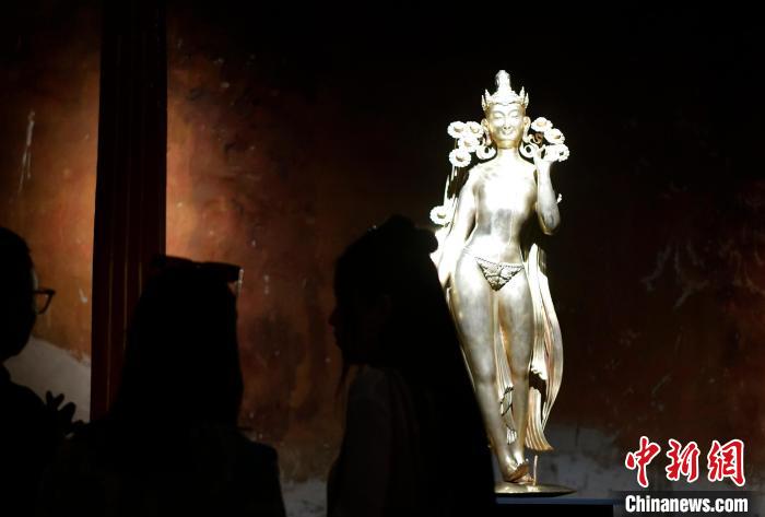 圖為觀眾正在欣賞展覽中的雕塑作品《八萬四千年》?！±盍?攝