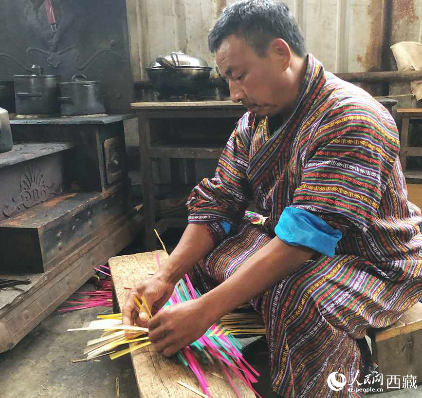 門巴族漢子愛明正在編織藤竹品。