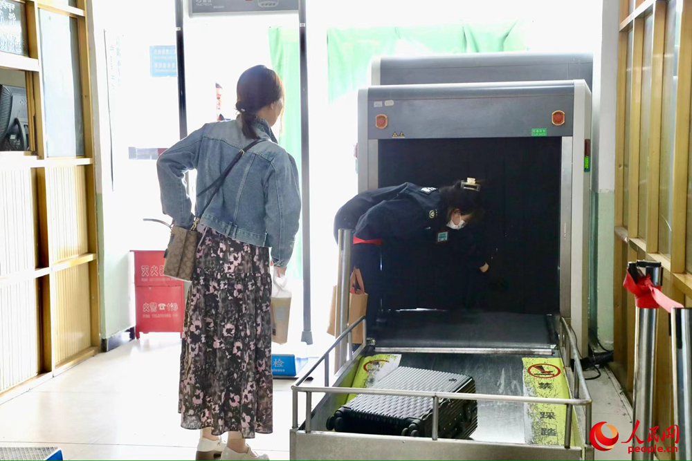 車站工作人員幫旅客提取行李。人民網(wǎng)記者 次仁羅布攝