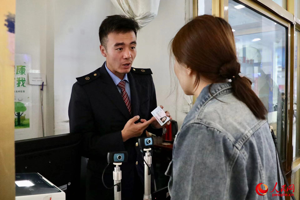 車站工作人員向旅客解答疑問。人民網(wǎng)記者 次仁羅布攝