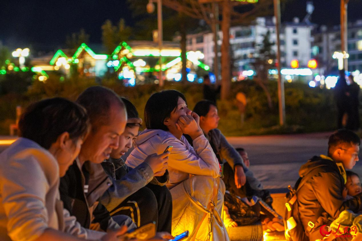 市民坐在西藏林芝市民族團結廣場臺階上欣賞音樂噴泉。人民網(wǎng)記者 趙晨攝